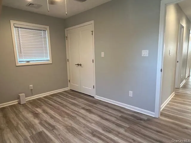 Unfurnished bedroom with dark wood-style flooring, a ceiling fan, and a closet Unfurnished bedroom with dark wood-style flooring, a ceiling fan, and a closet