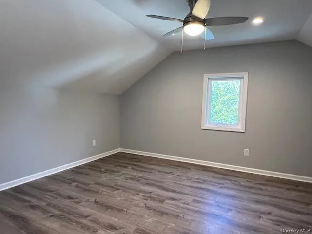 Bonus room with lofted ceiling and dark wood finished floors Bonus room with lofted ceiling and dark wood finished floors