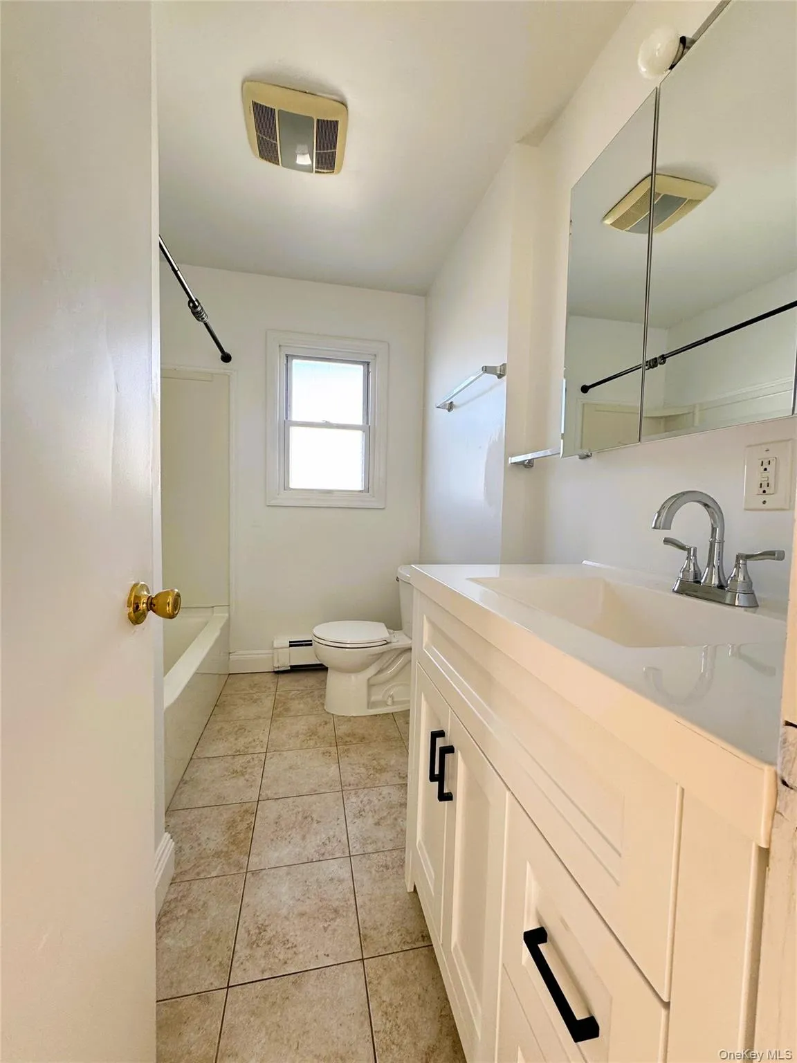 Full bath with vanity, shower / bathtub combination, light tile patterned floors, and baseboard heating Full bath with vanity, shower / bathtub combination, light tile patterned floors, and baseboard heating