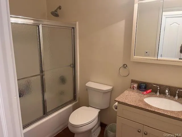 Bathroom featuring enclosed tub / shower combo and vanity Bathroom featuring enclosed tub / shower combo and vanity