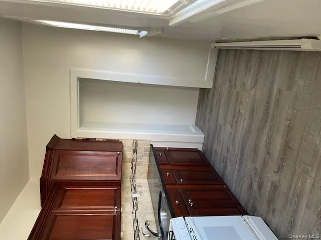 Kitchen featuring stove, dark wood-style flooring, dark stone countertops, baseboard heating, and tasteful backsplash Kitchen featuring stove, dark wood-style flooring, dark stone countertops, baseboard heating, and tasteful backsplash