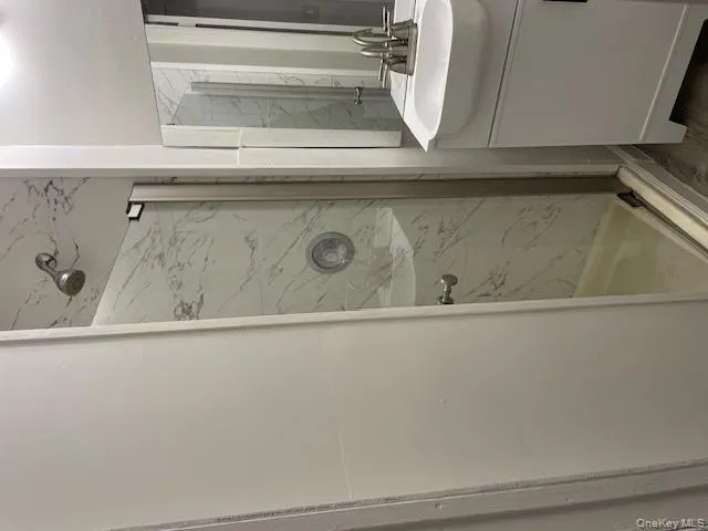 Full bathroom featuring vanity and a marble finish shower Full bathroom featuring vanity and a marble finish shower