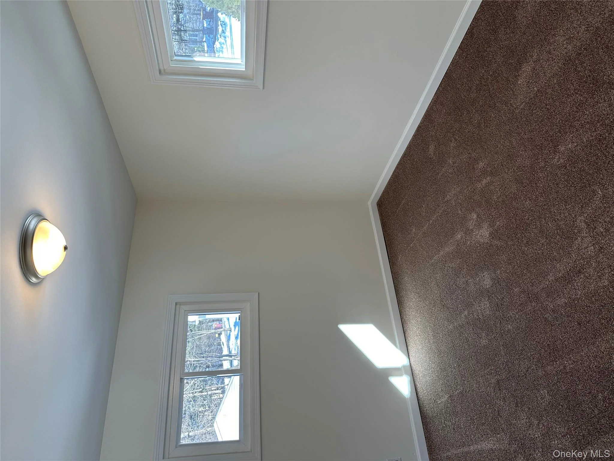 Spare room featuring plenty of natural light and dark carpet Spare room featuring plenty of natural light and dark carpet