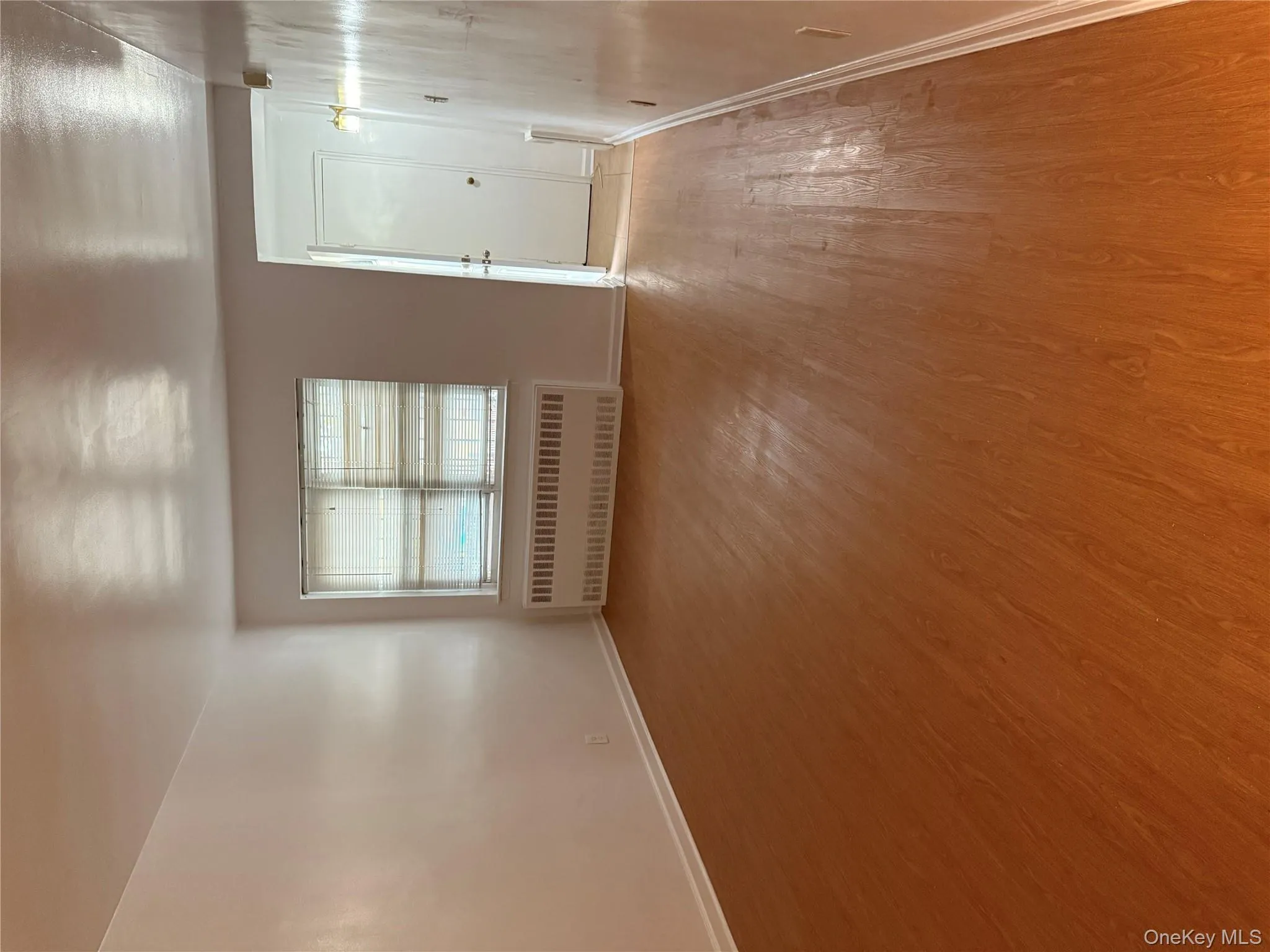 Empty room featuring radiator heating unit and light wood-type flooring Empty room featuring radiator heating unit and light wood-type flooring