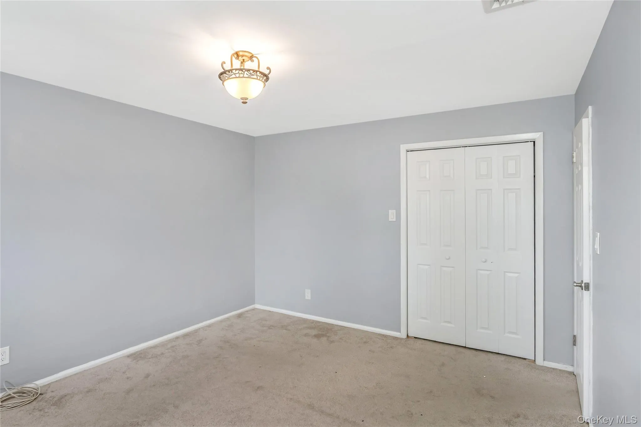 Unfurnished bedroom with carpet floors and a closet Unfurnished bedroom with carpet floors and a closet