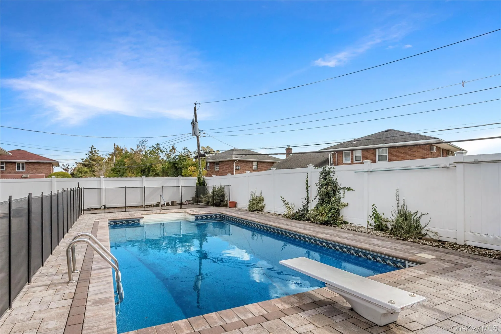 View of swimming pool with a fenced backyard, a patio, and a diving board View of swimming pool with a fenced backyard, a patio, and a diving board
