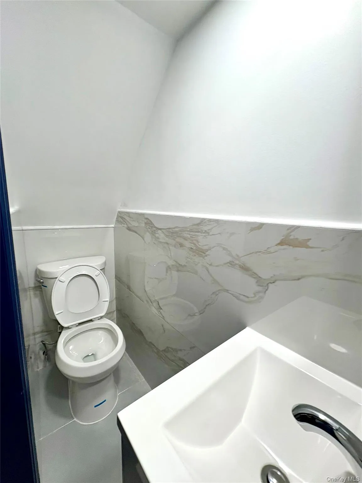 Bathroom with vanity, wainscoting, and tile walls Bathroom with vanity, wainscoting, and tile walls