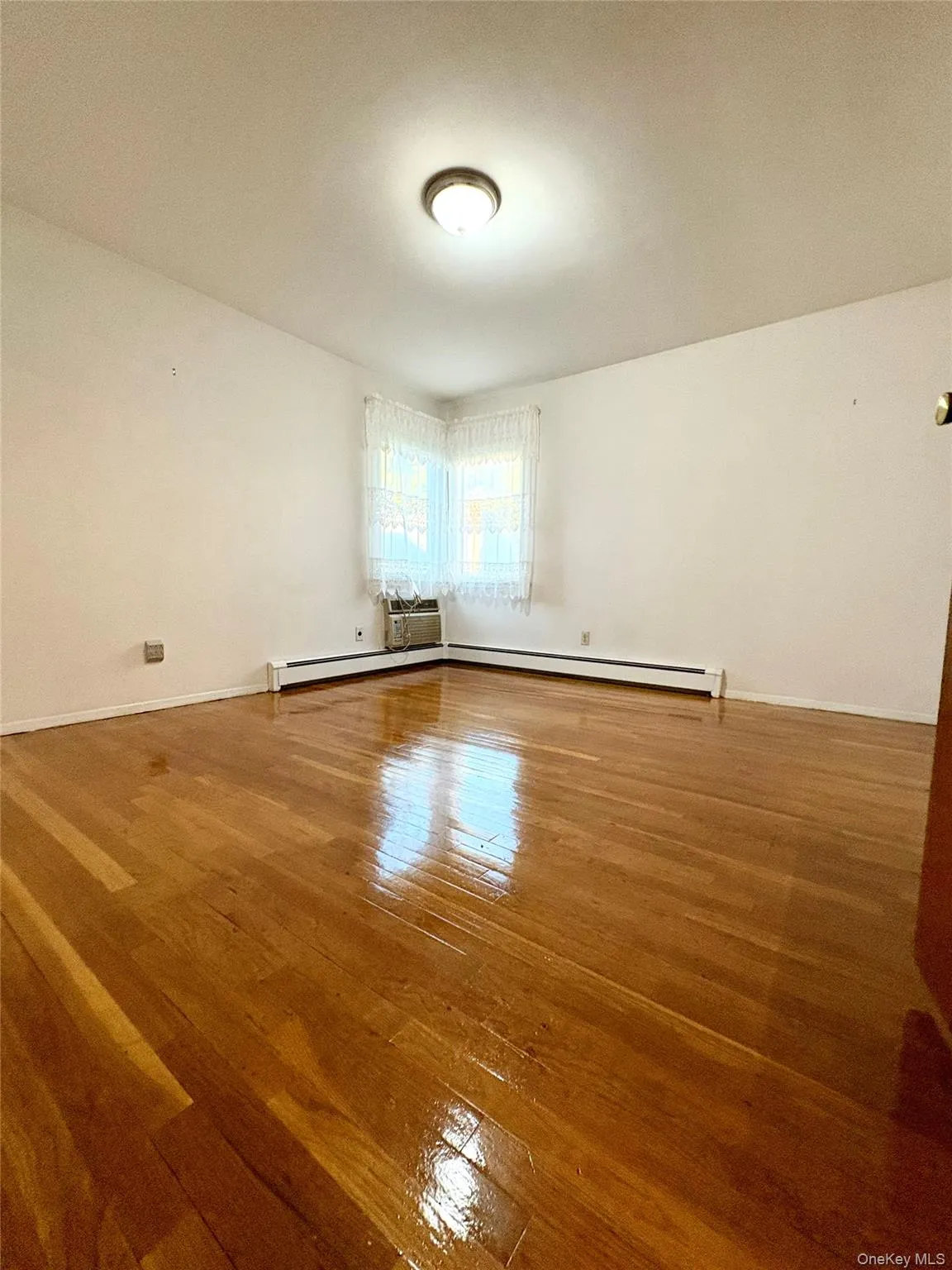 Unfurnished room with light wood-style flooring and baseboards Unfurnished room with light wood-style flooring and baseboards