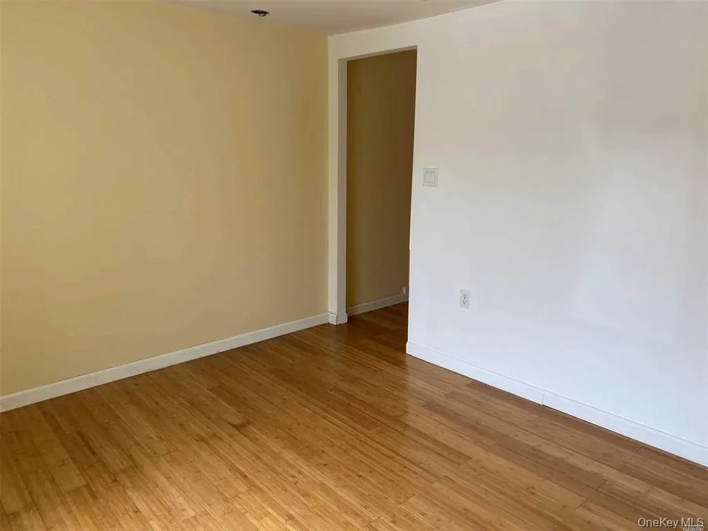 Unfurnished room with baseboards and light wood finished floors Unfurnished room with baseboards and light wood finished floors