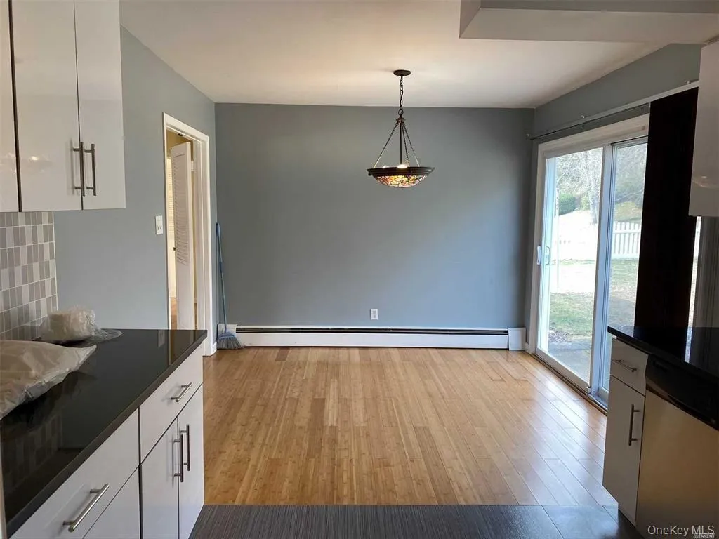 Unfurnished dining area with light wood-type flooring and baseboard heating Unfurnished dining area with light wood-type flooring and baseboard heating