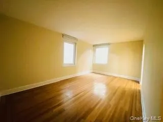 Spare room featuring wood finished floors and baseboards Spare room featuring wood finished floors and baseboards