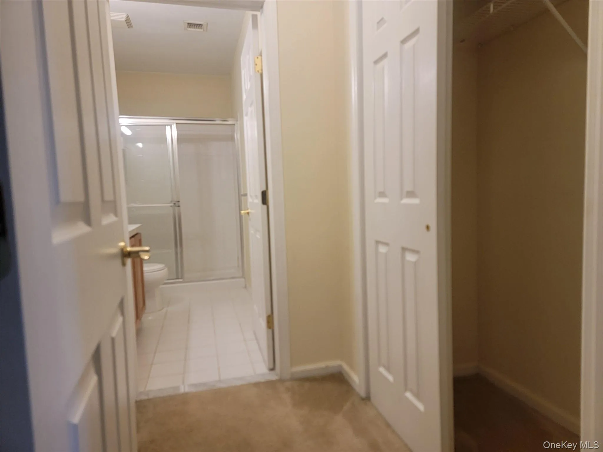 Hall with light tile patterned floors and light colored carpet Hall with light tile patterned floors and light colored carpet