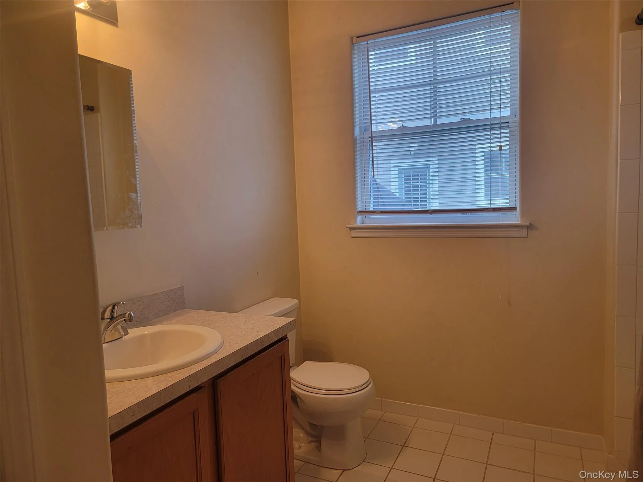 Bathroom with vanity, light tile patterned floors, and a shower Bathroom with vanity, light tile patterned floors, and a shower