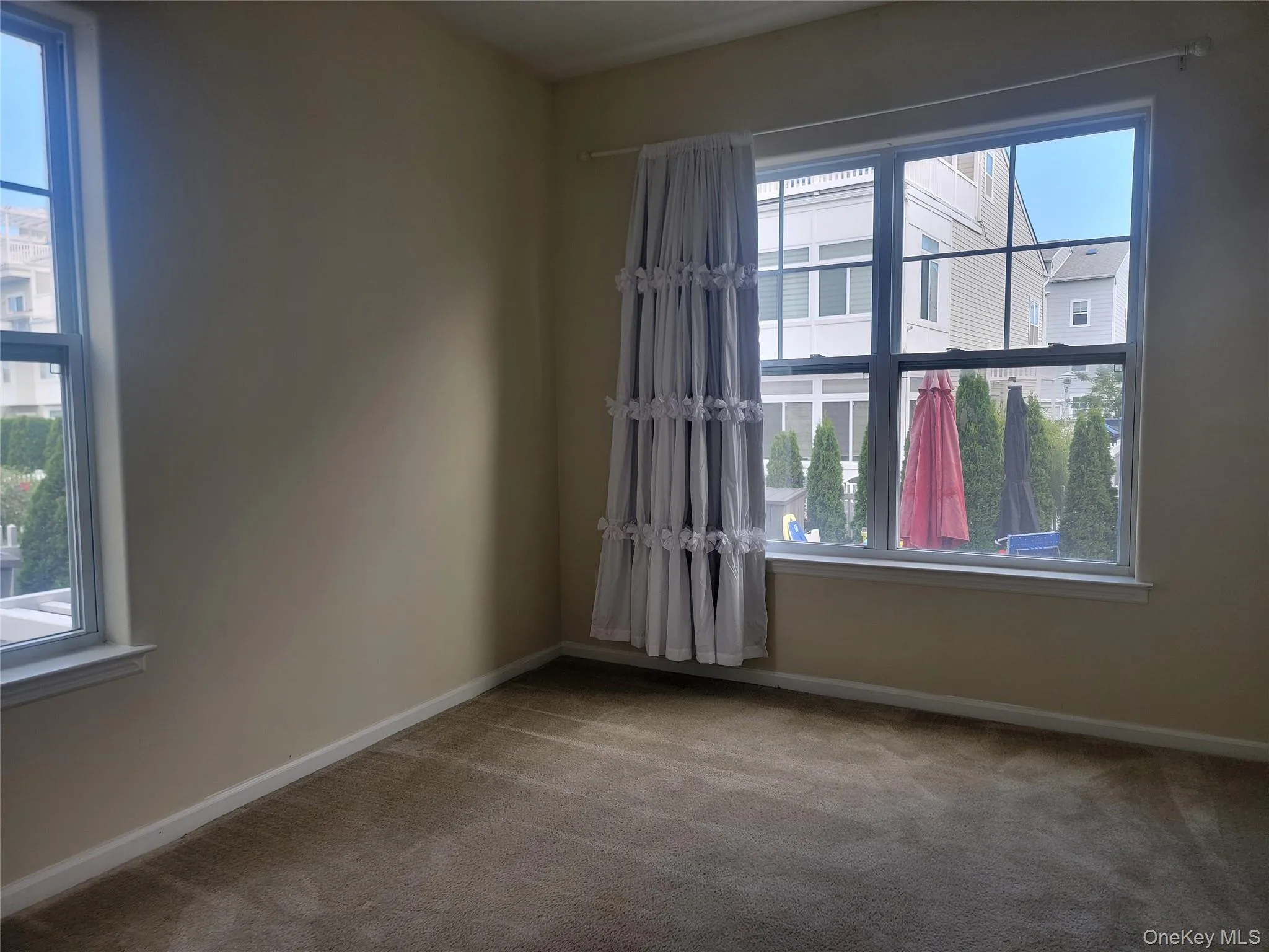 Unfurnished room with carpet and baseboards Unfurnished room with carpet and baseboards