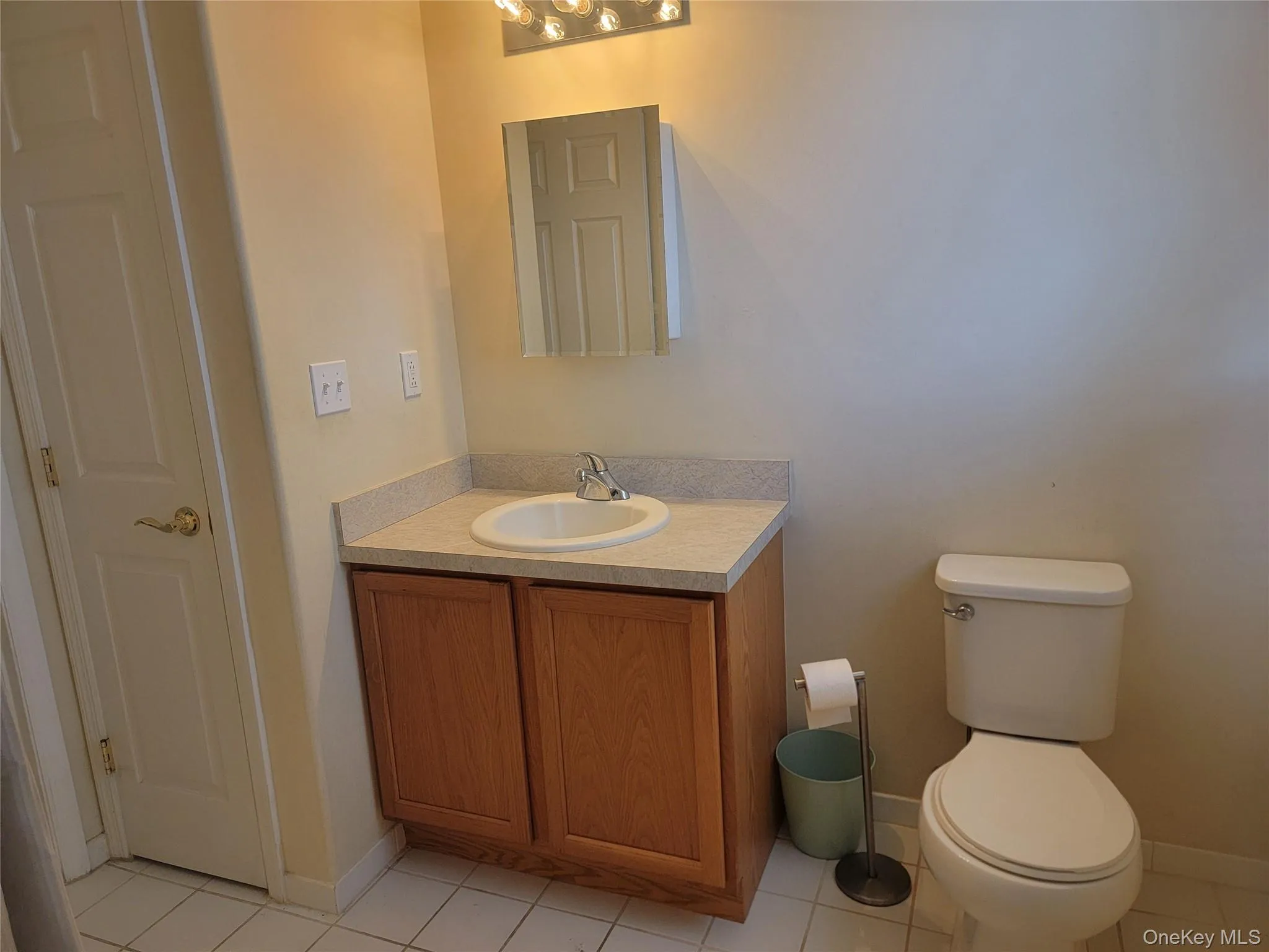 Bathroom with light tile patterned flooring and vanity Bathroom with light tile patterned flooring and vanity