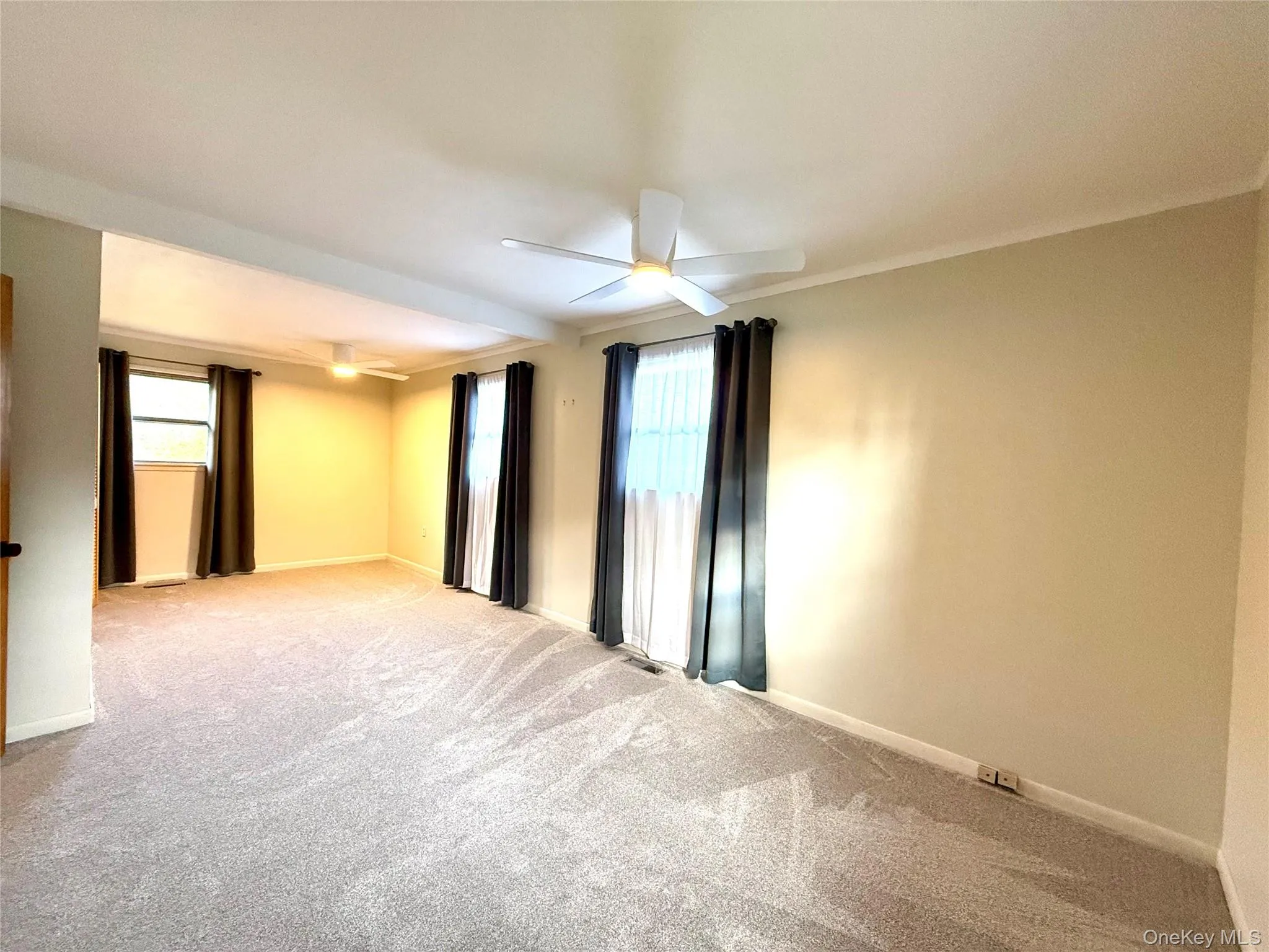 Unfurnished room with light colored carpet and ceiling fan Unfurnished room with light colored carpet and ceiling fan