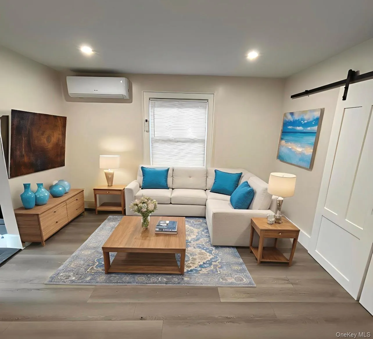 Living area with a barn door, wood finished floors, an AC wall unit, and recessed lighting Living area with a barn door, wood finished floors, an AC wall unit, and recessed lighting