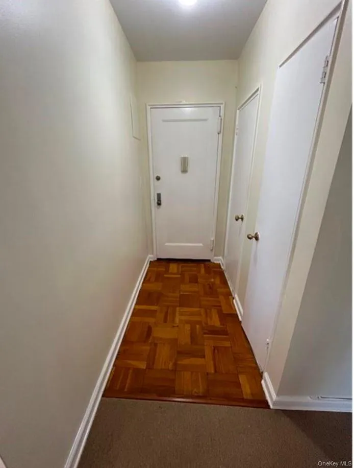 Hallway featuring dark parquet flooring Hallway featuring dark parquet flooring