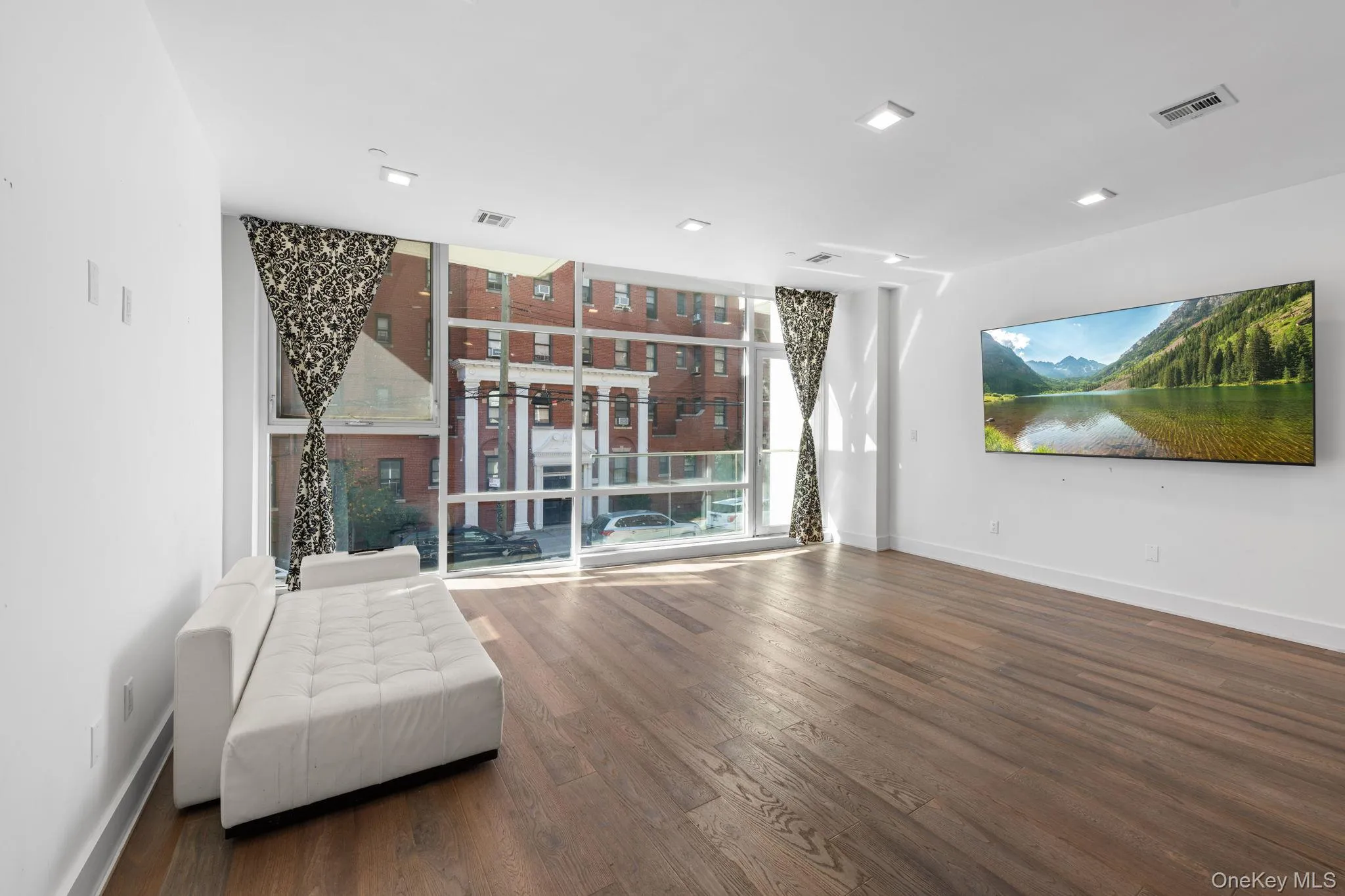 Unfurnished room with a wall of windows and dark wood finished floors Unfurnished room with a wall of windows and dark wood finished floors