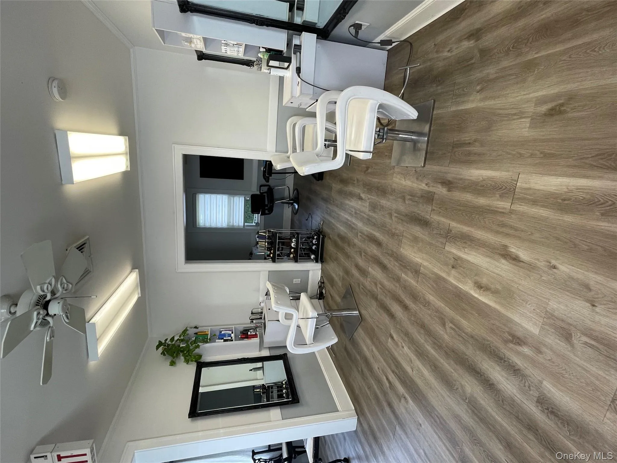 Living room featuring dark wood-type flooring, ceiling fan, and ornamental molding Living room featuring dark wood-type flooring, ceiling fan, and ornamental molding
