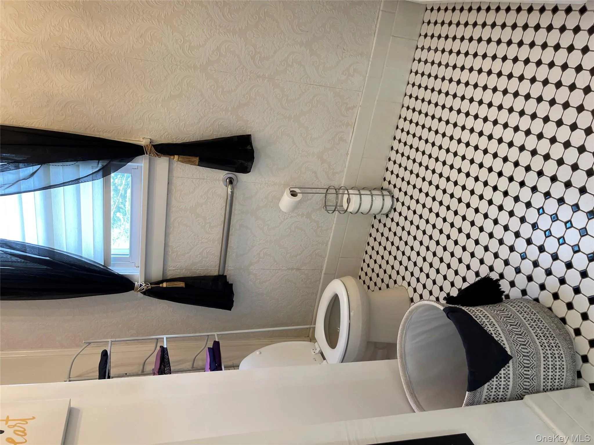 Half bathroom featuring baseboards and wallpapered walls Half bathroom featuring baseboards and wallpapered walls