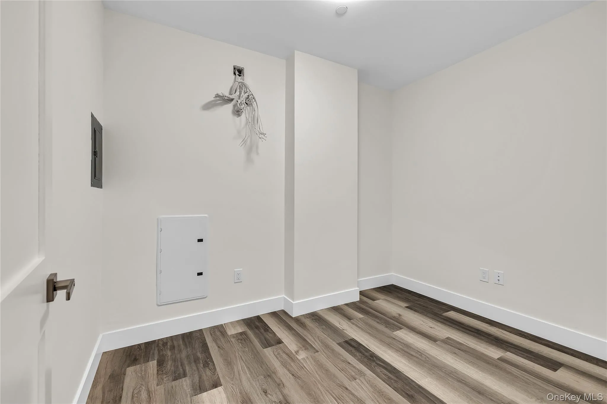 Spare room featuring baseboards and wood finished floors Spare room featuring baseboards and wood finished floors