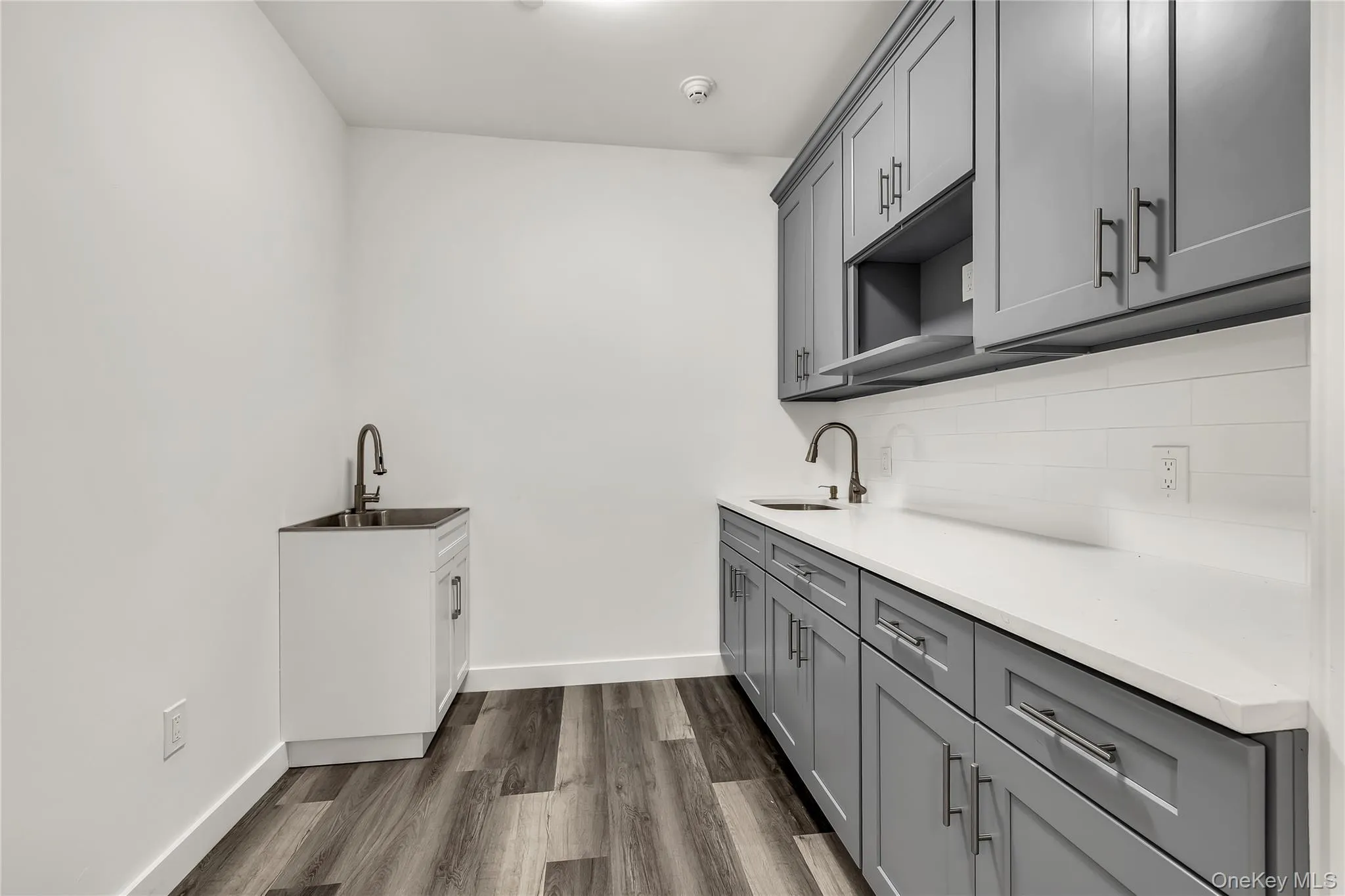 Laundry room with dark wood-type flooring and baseboards Laundry room with dark wood-type flooring and baseboards