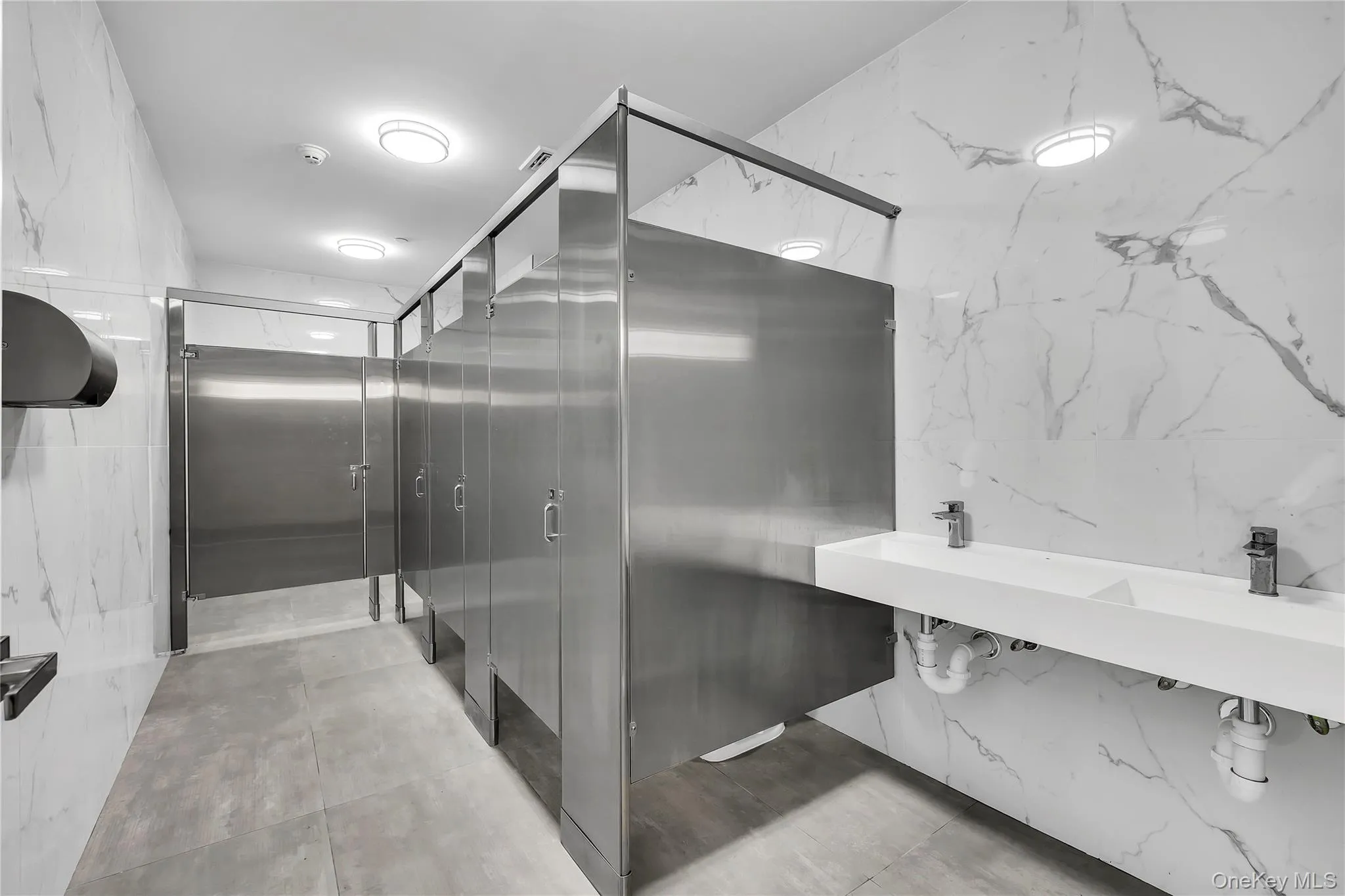 Bathroom with elevator, tile walls, and double vanity Bathroom with elevator, tile walls, and double vanity