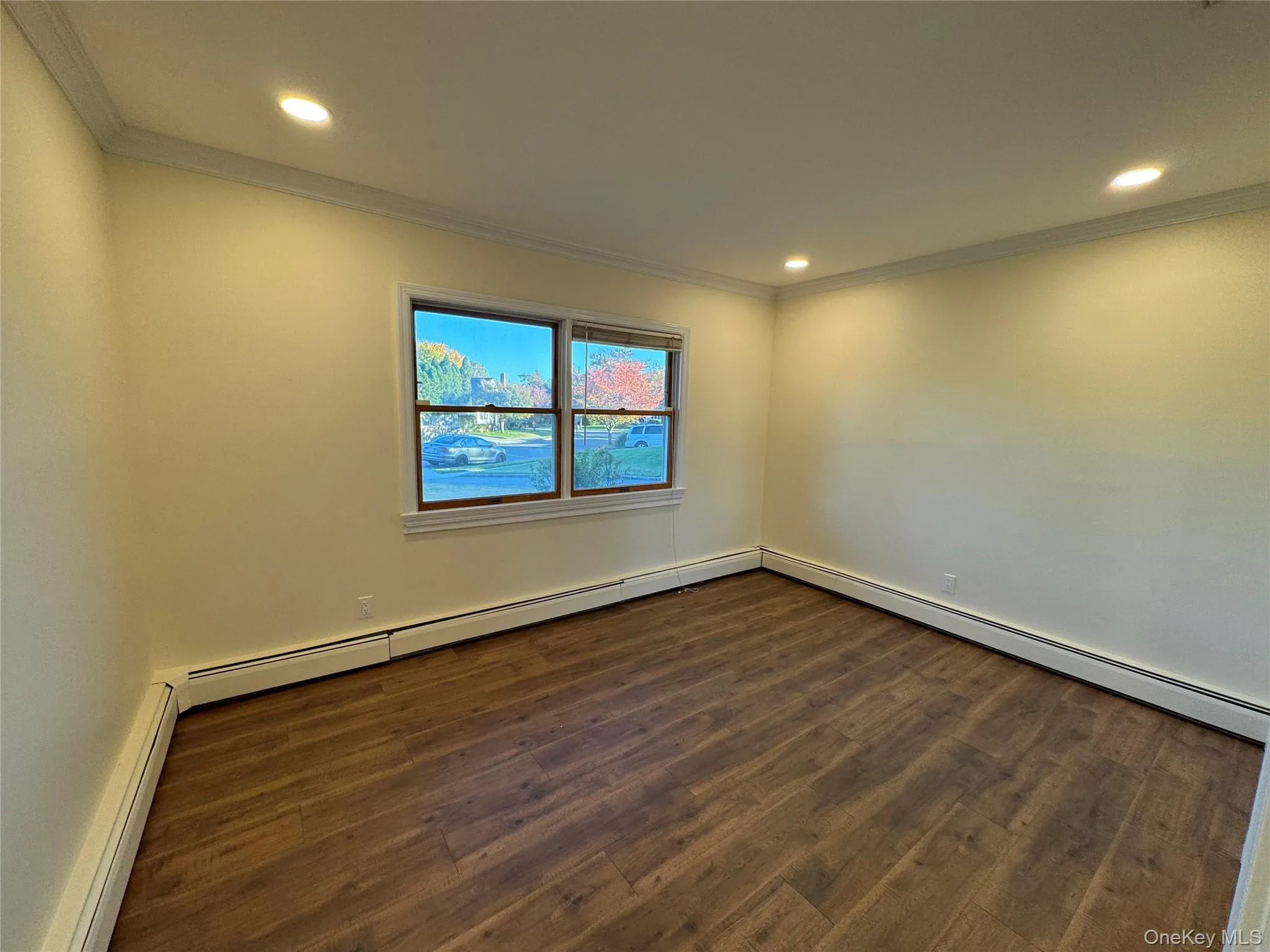 Bedroom with crown molding, dark wood-style floors, a baseboard heating unit, and recessed lighting Bedroom with crown molding, dark wood-style floors, a baseboard heating unit, and recessed lighting