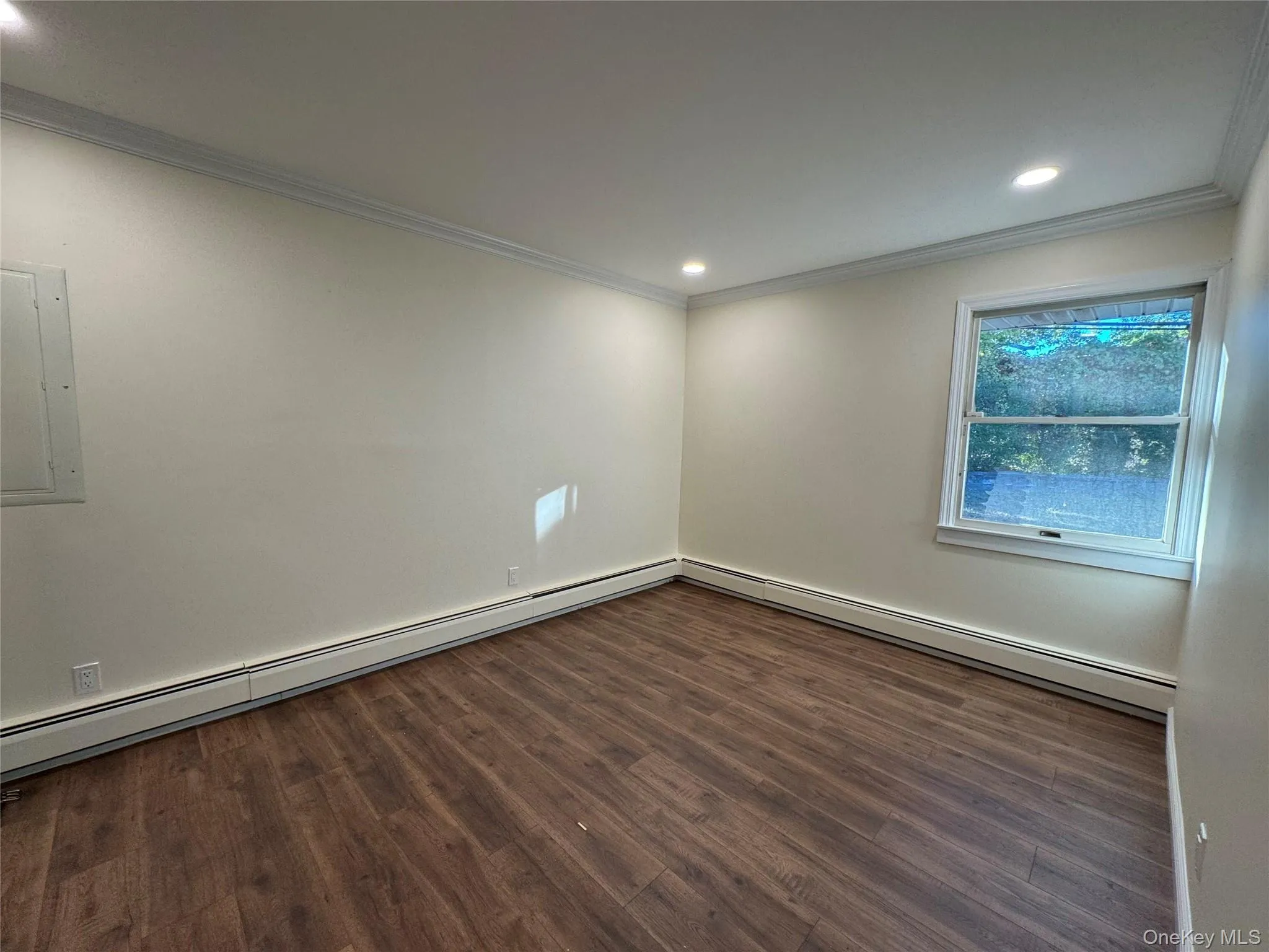 Unfurnished room featuring crown molding, a baseboard radiator, dark wood-type flooring, electric panel, and recessed lighting Unfurnished room featuring crown molding, a baseboard radiator, dark wood-type flooring, electric panel, and recessed lighting