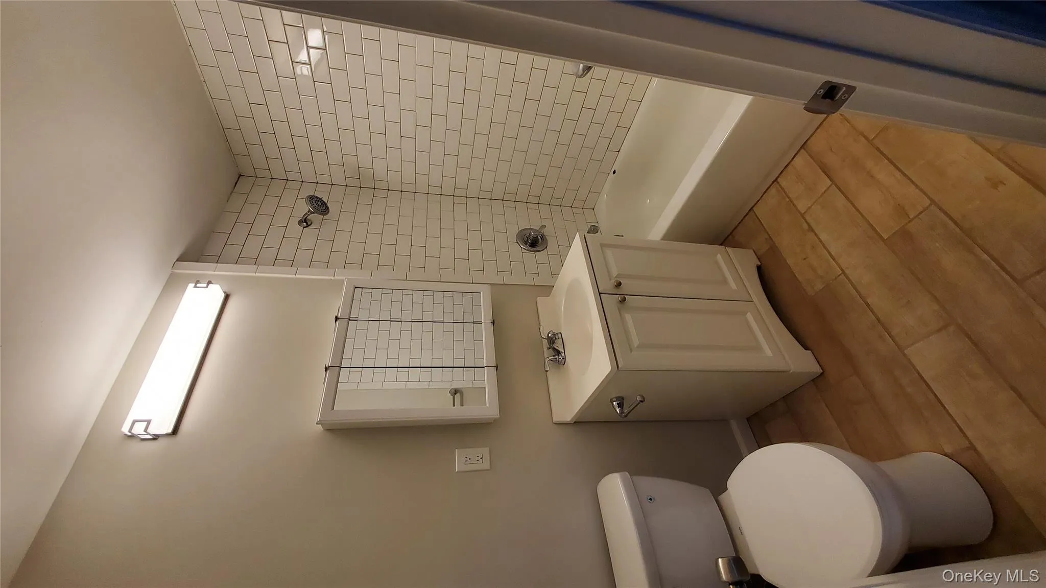 Bathroom with vanity, shower / tub combination, and light wood-style floors Bathroom with vanity, shower / tub combination, and light wood-style floors