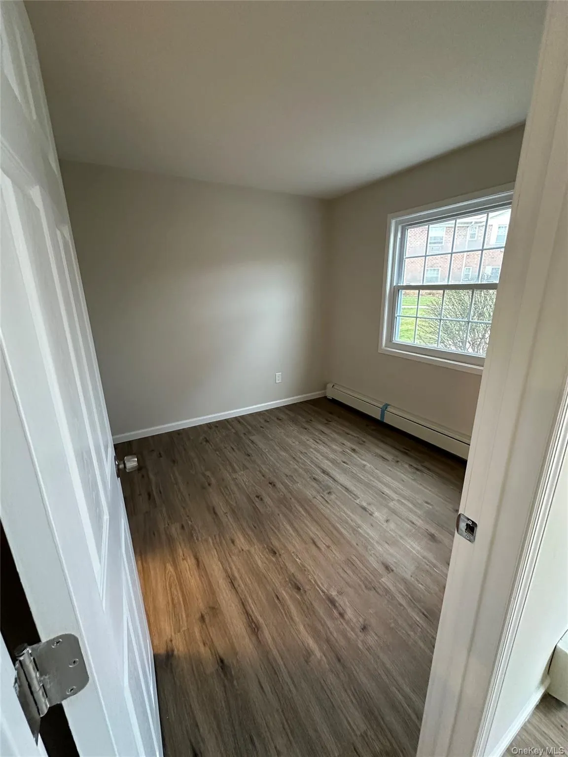 Unfurnished room featuring light wood-type flooring and a baseboard heating unit Unfurnished room featuring light wood-type flooring and a baseboard heating unit