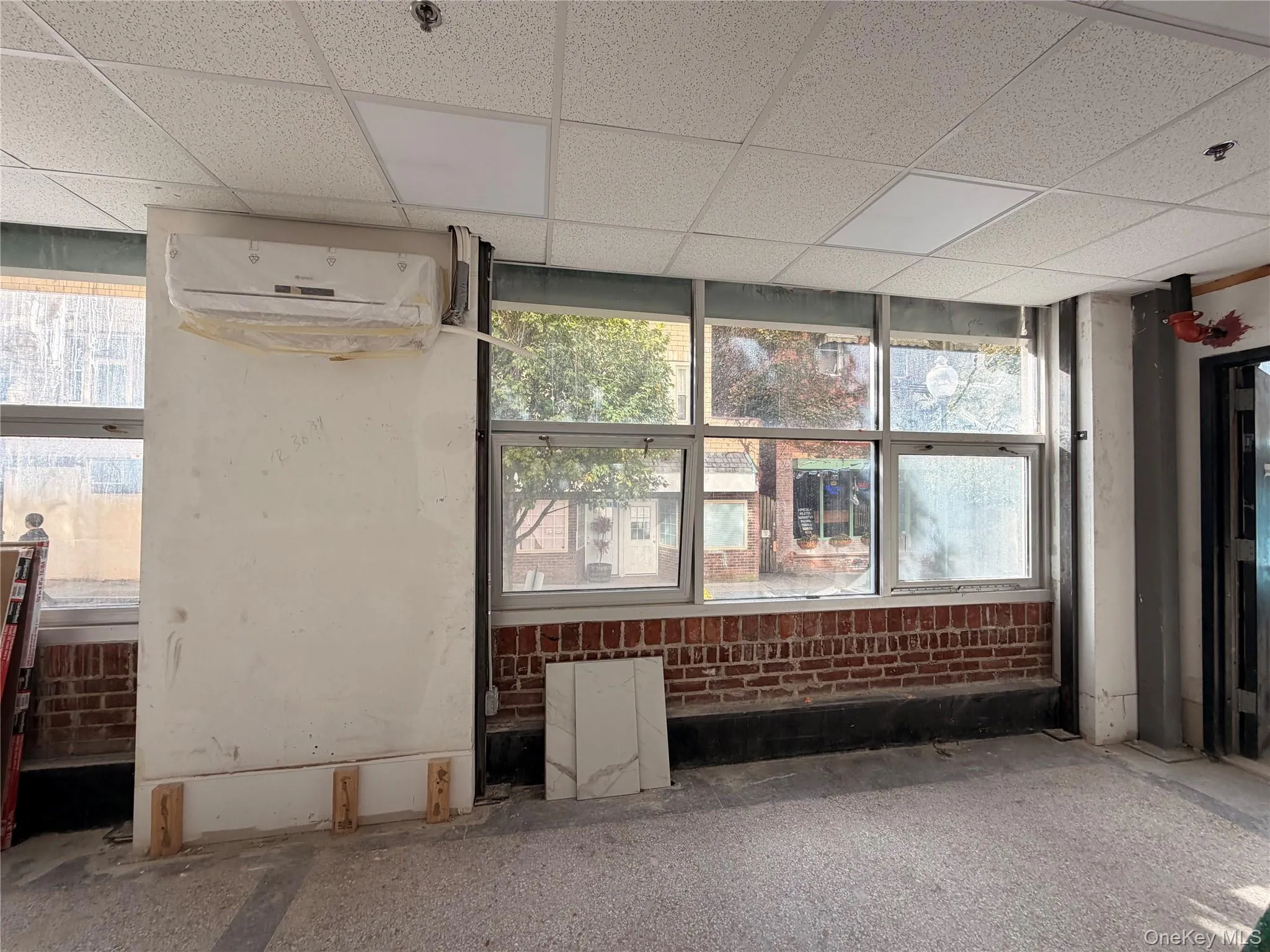 Unfurnished room with a drop ceiling and a wall unit AC Unfurnished room with a drop ceiling and a wall unit AC