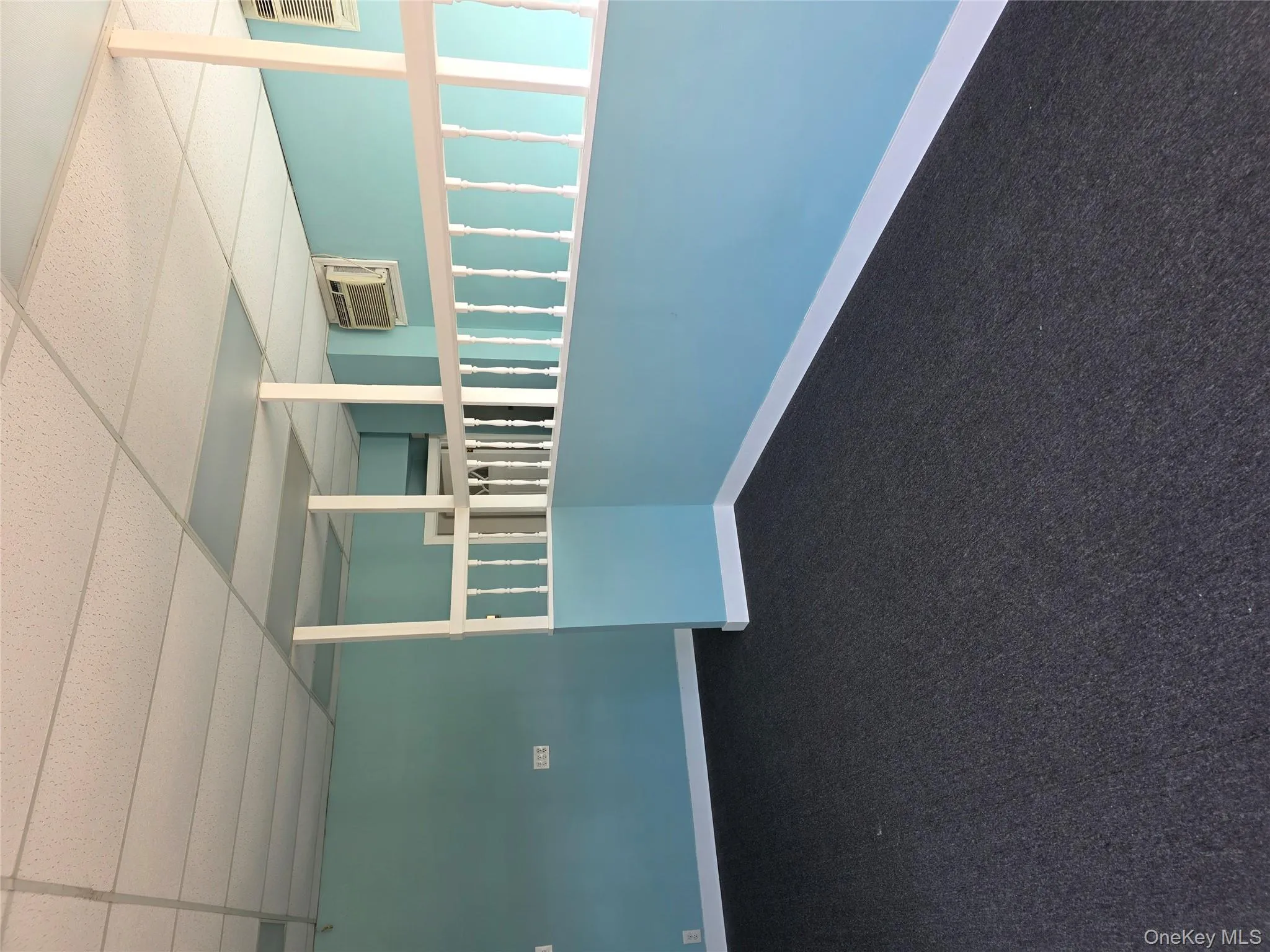 Spare room featuring a drop ceiling and a wall mounted air conditioner Spare room featuring a drop ceiling and a wall mounted air conditioner