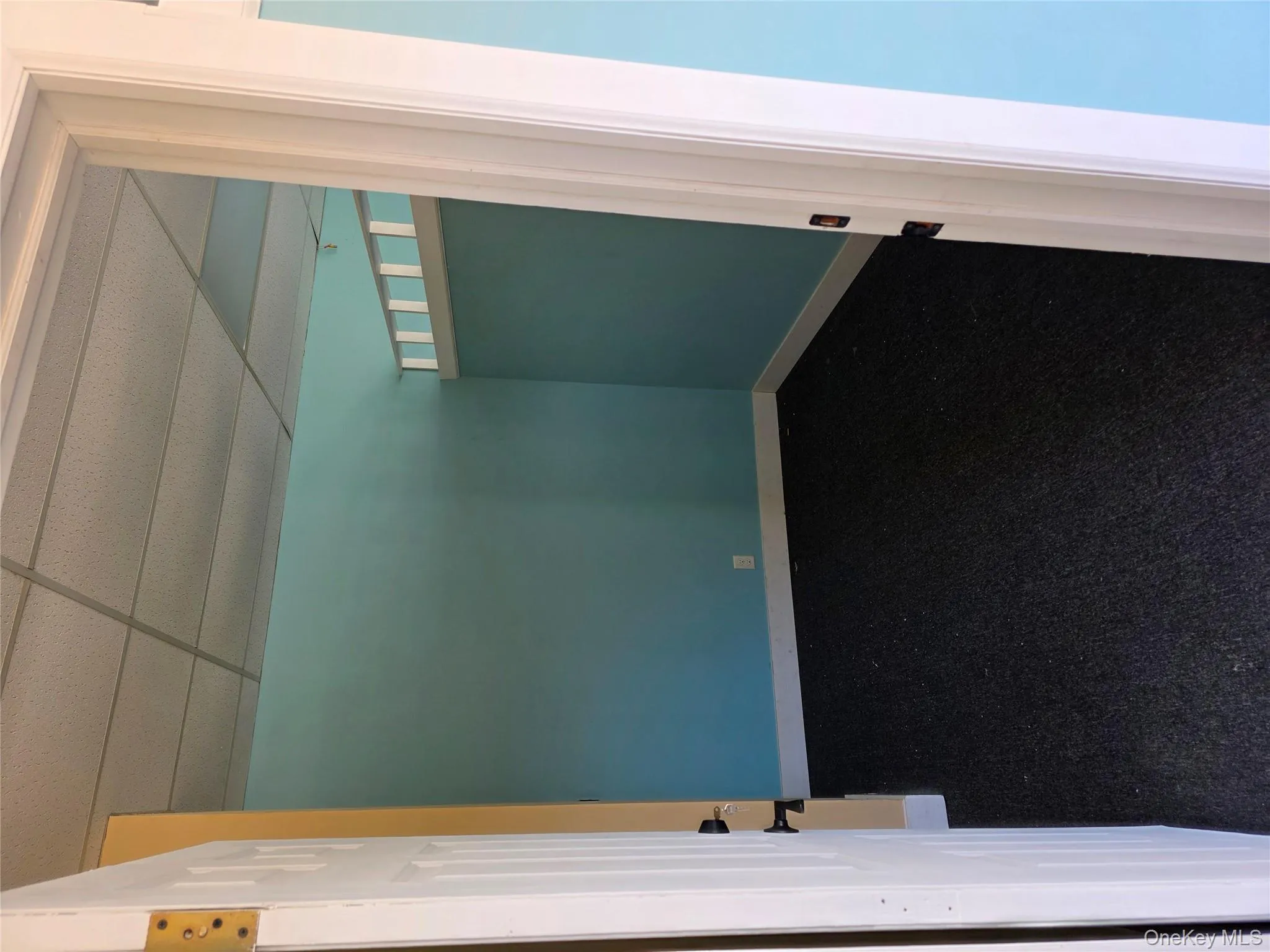 Empty room with a drop ceiling and baseboards Empty room with a drop ceiling and baseboards