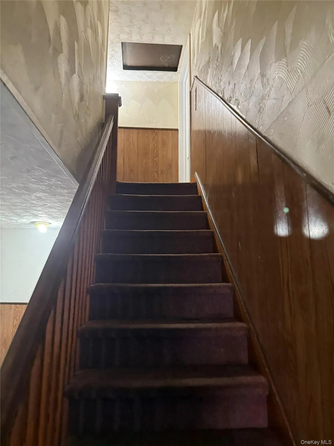 Staircase featuring wooden walls Staircase featuring wooden walls