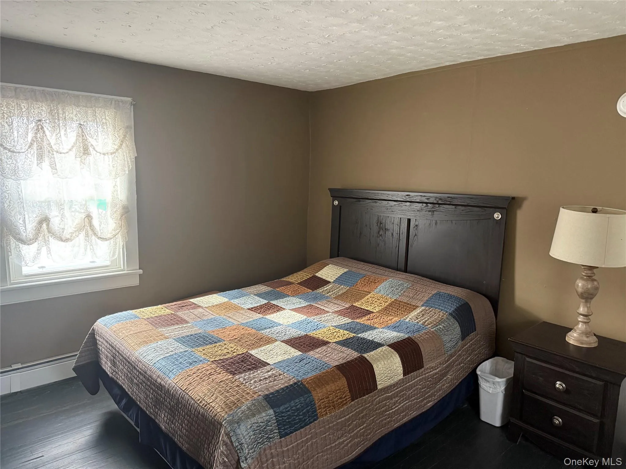 Bedroom featuring wood finished floors and a textured ceiling Bedroom featuring wood finished floors and a textured ceiling