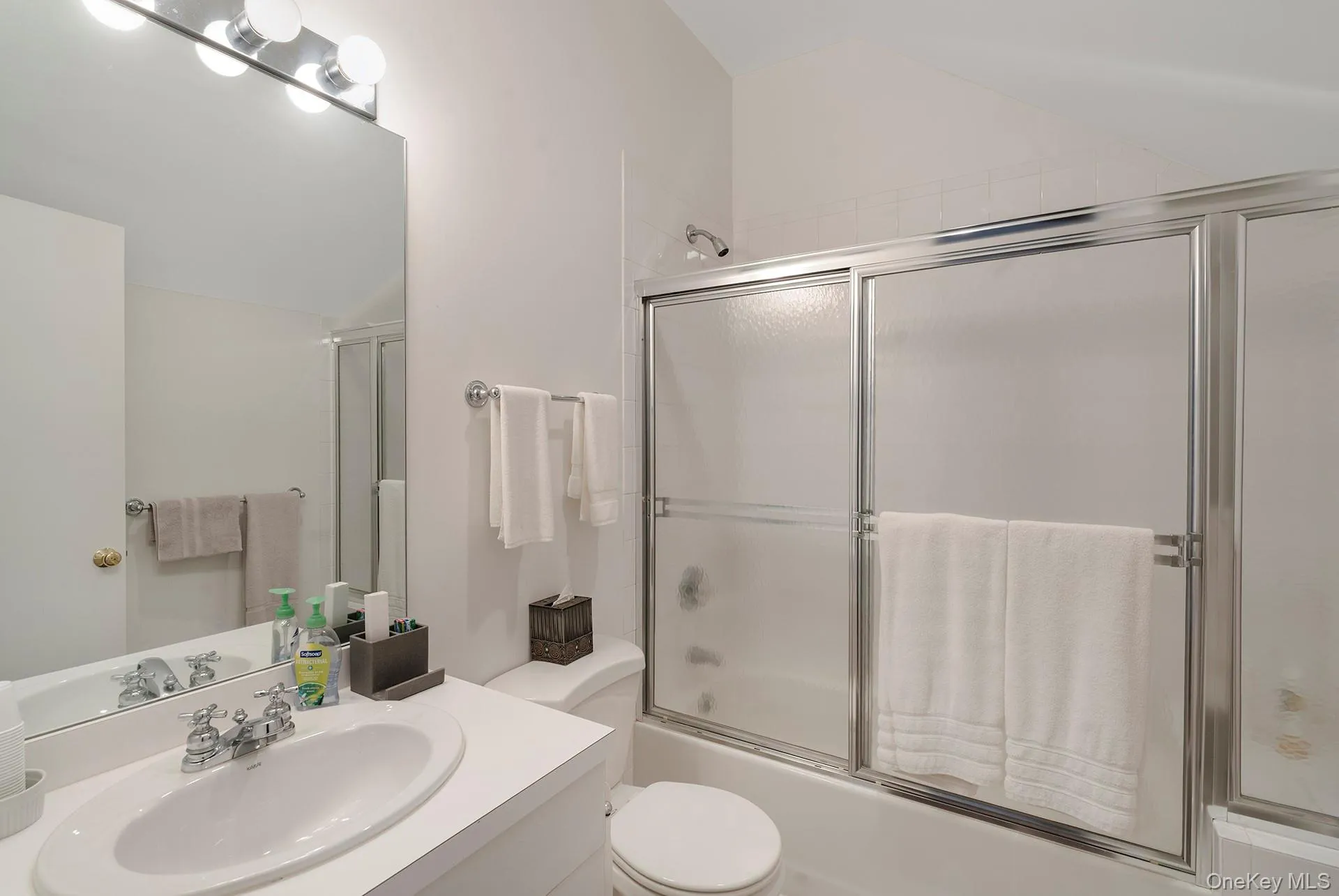 Bathroom with vanity, enclosed tub / shower combo, and lofted ceiling Bathroom with vanity, enclosed tub / shower combo, and lofted ceiling