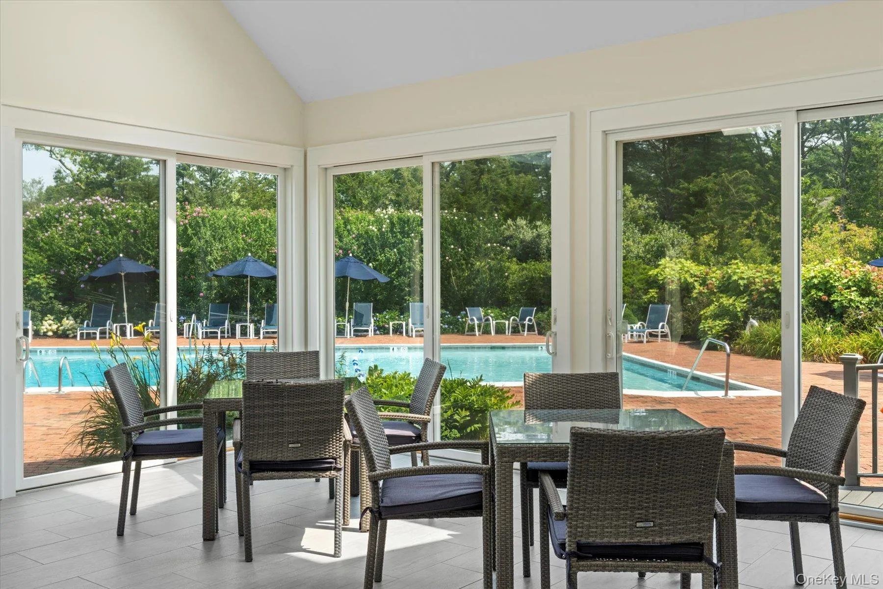 Sunroom / solarium with vaulted ceiling and view of scattered trees Sunroom / solarium with vaulted ceiling and view of scattered trees
