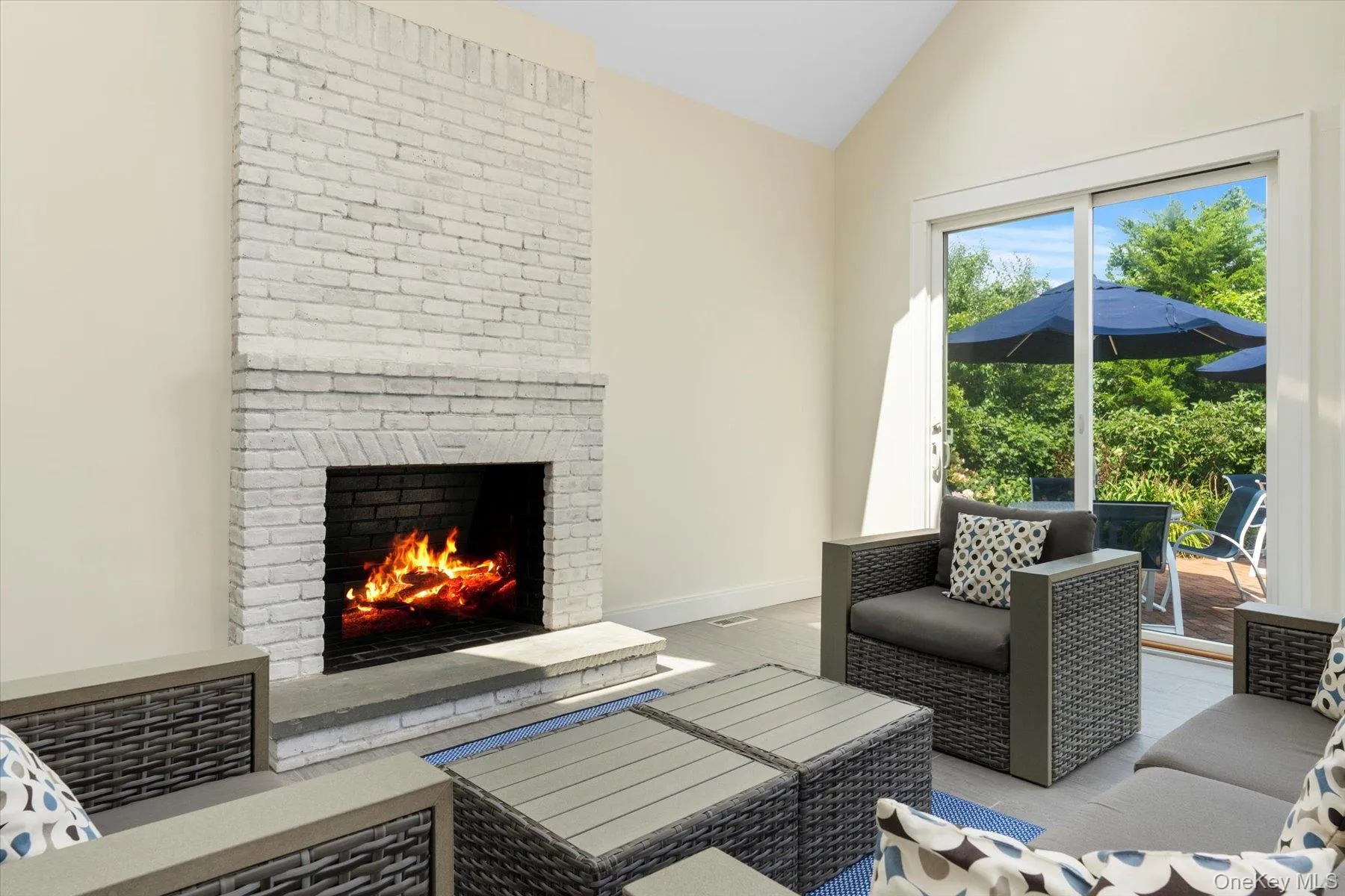 Living area featuring vaulted ceiling, a brick fireplace, and wood finished floors Living area featuring vaulted ceiling, a brick fireplace, and wood finished floors
