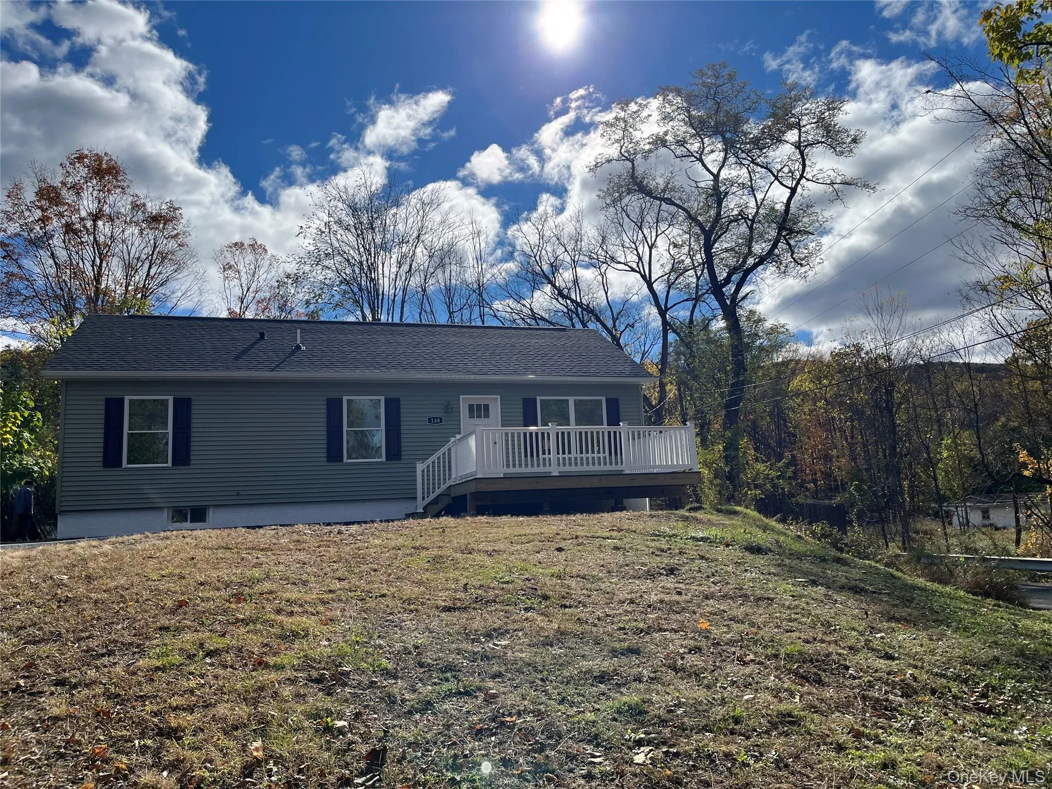 Rear view of house featuring a deck, a yard, and a shingled roof Rear view of house featuring a deck, a yard, and a shingled roof