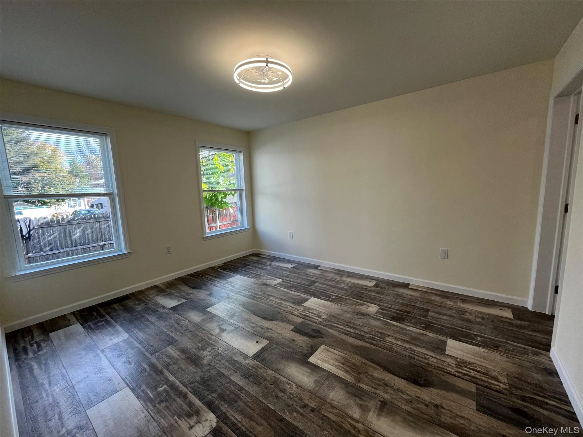 Empty room featuring dark wood finished floors and baseboards Empty room featuring dark wood finished floors and baseboards