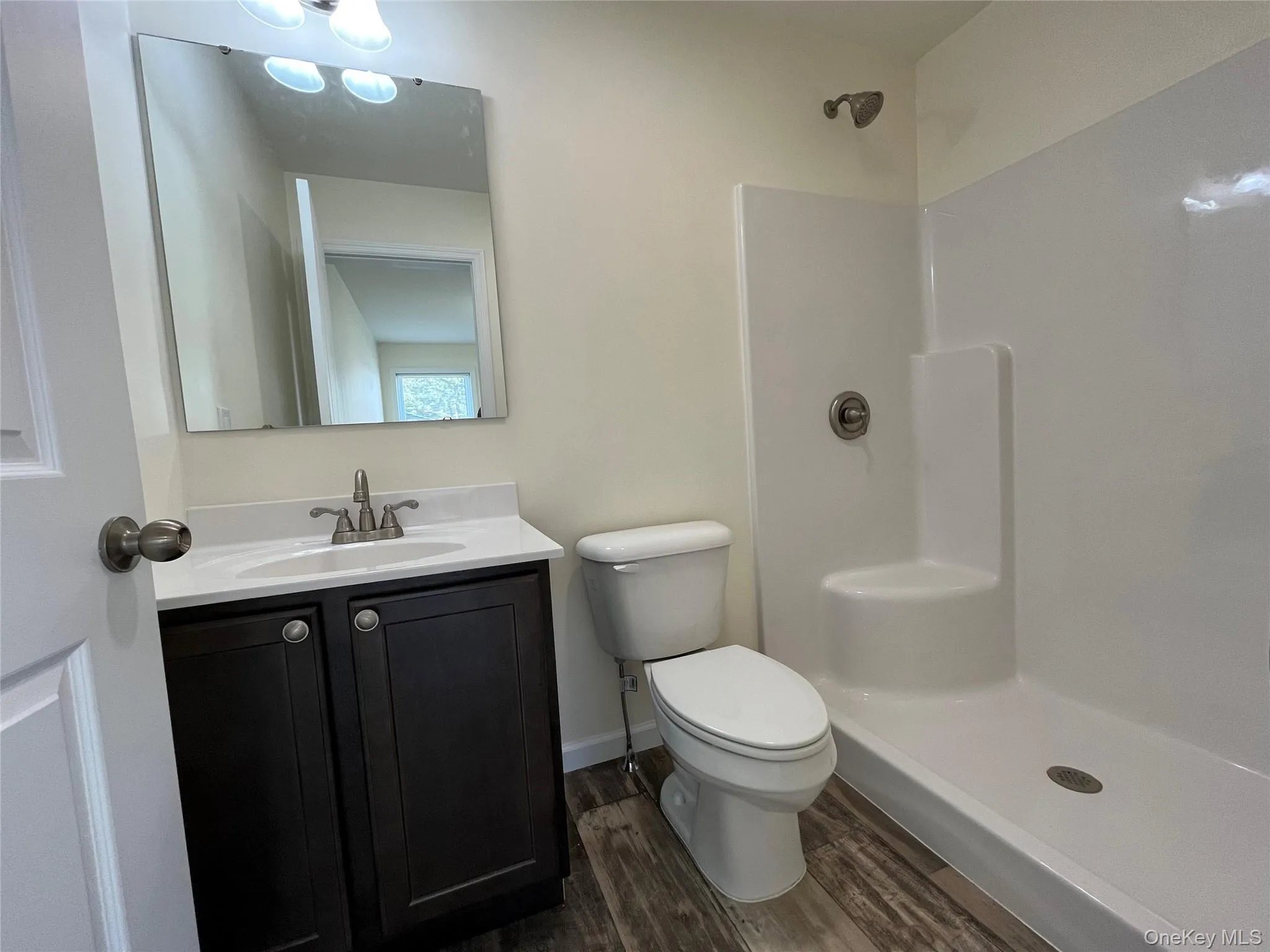 Bathroom featuring vanity, dark wood finished floors, and a shower stall Bathroom featuring vanity, dark wood finished floors, and a shower stall