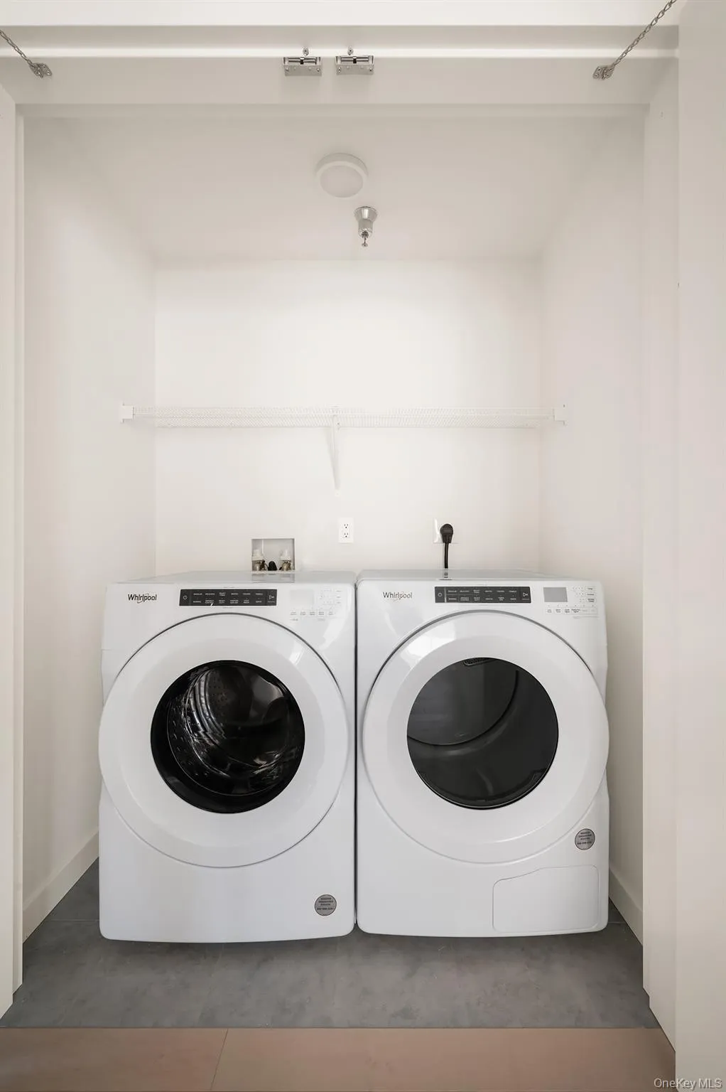 Laundry room featuring washer and dryer and dark tile patterned flooring Laundry room featuring washer and dryer and dark tile patterned flooring