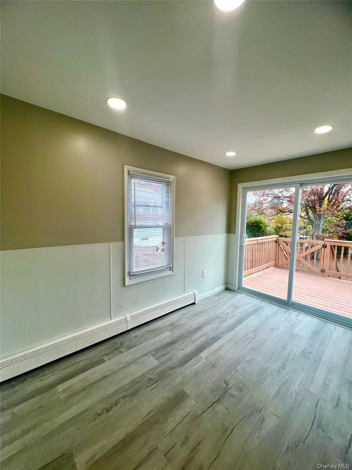 Spare room featuring a baseboard heating unit, wood finished floors, plenty of natural light, and recessed lighting Spare room featuring a baseboard heating unit, wood finished floors, plenty of natural light, and recessed lighting
