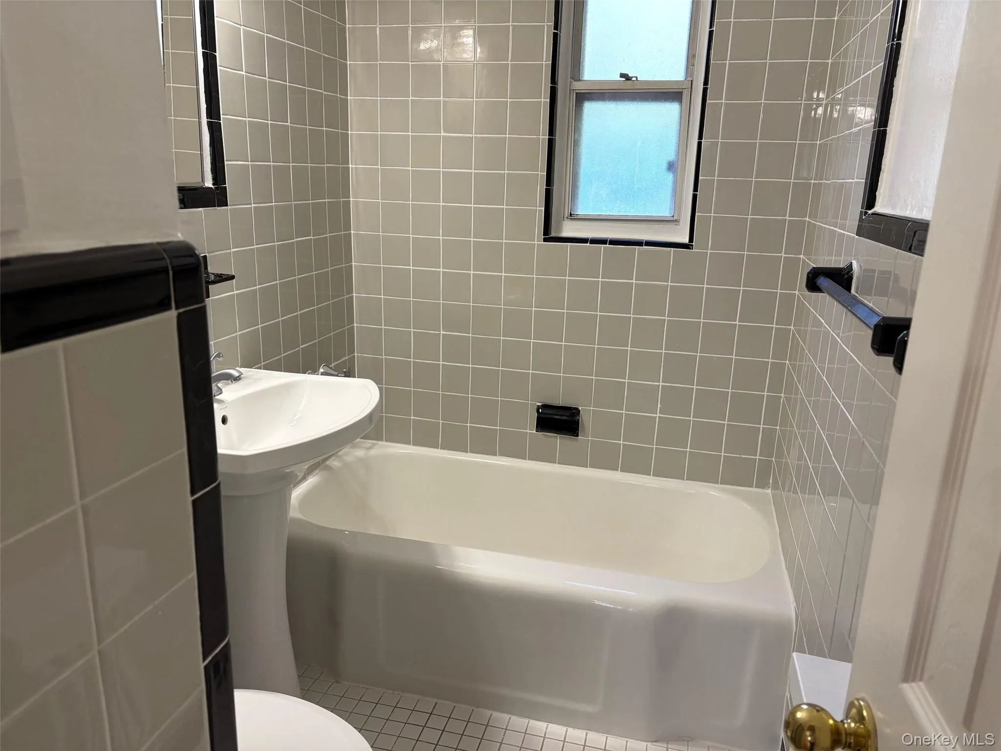 Full bath featuring washtub / shower combination and tile patterned floors Full bath featuring washtub / shower combination and tile patterned floors