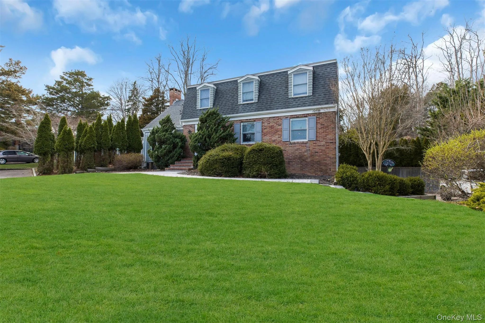 View of front of house with brick siding, a front yard, and roof with shingles View of front of house with brick siding, a front yard, and roof with shingles