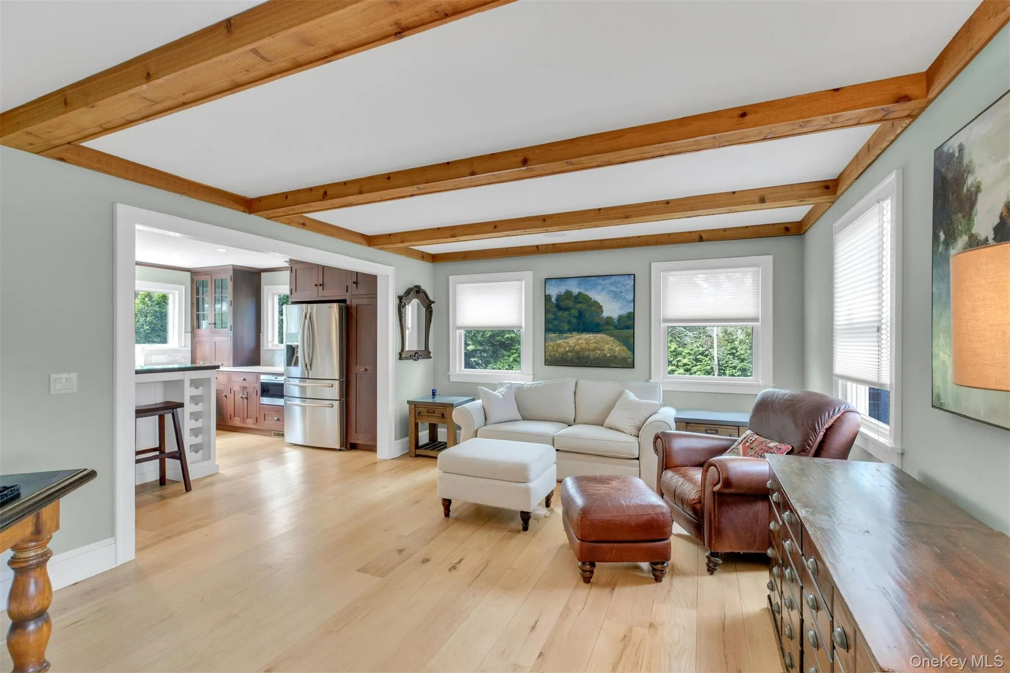 Living area featuring beam ceiling and light wood-style flooring Living area featuring beam ceiling and light wood-style flooring