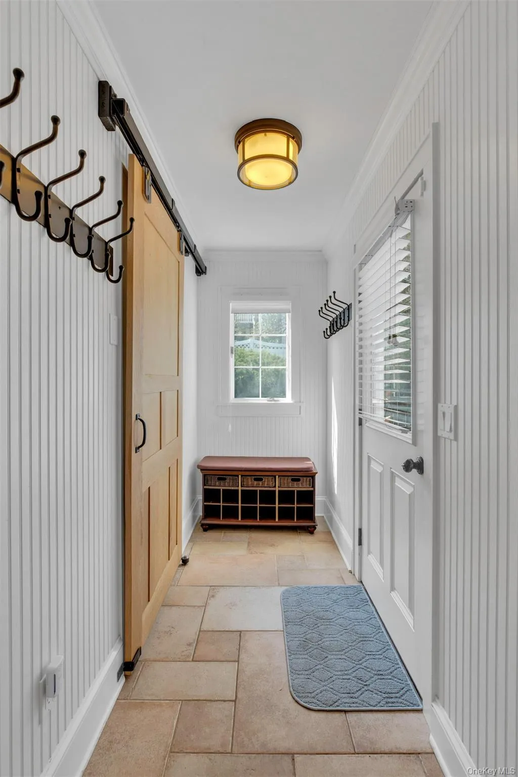 Mudroom featuring ornamental molding and a barn door Mudroom featuring ornamental molding and a barn door
