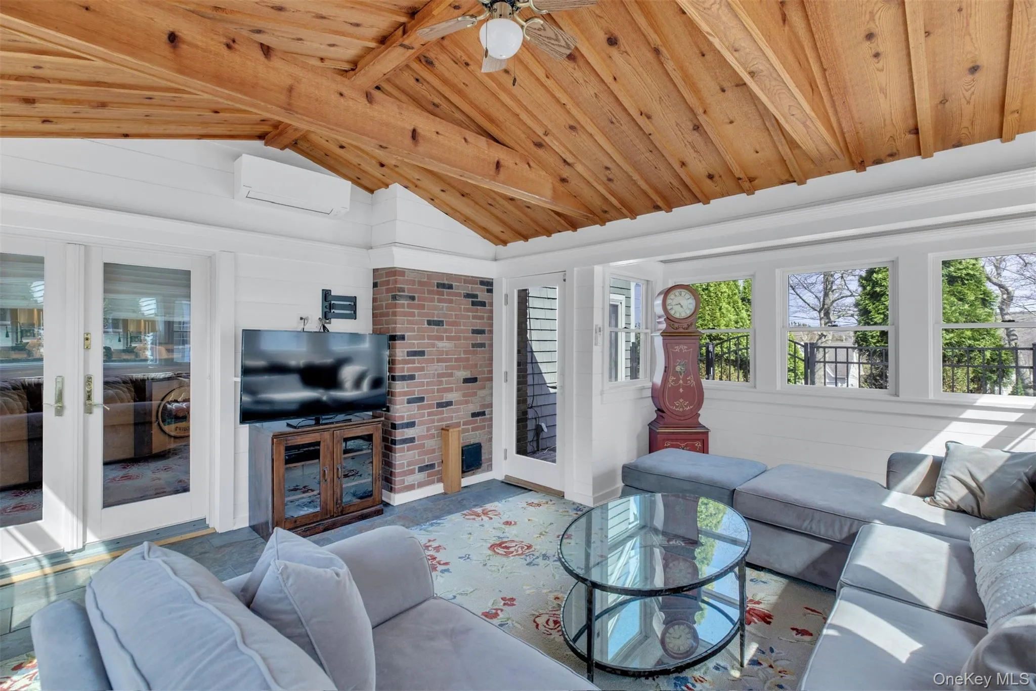 Living room with wood ceiling, an AC wall unit, and a ceiling fan Living room with wood ceiling, an AC wall unit, and a ceiling fan
